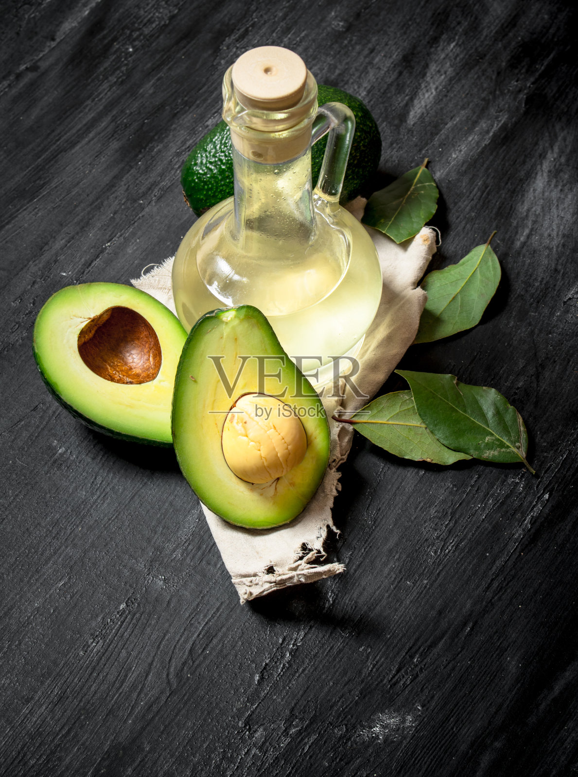 油和鳄梨。以黑色木制为背景。照片摄影图片