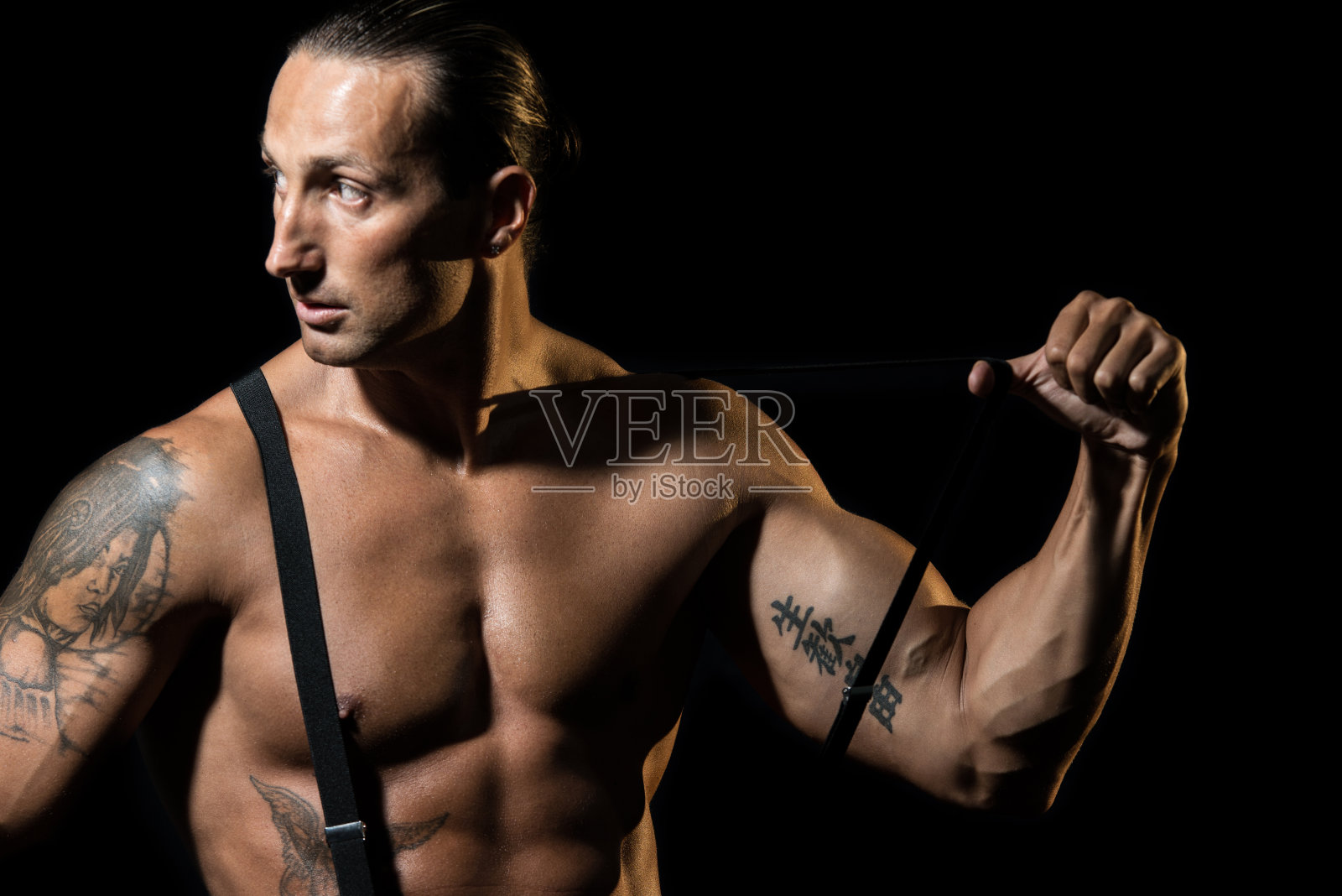 性感的男人与黑色吊带在裸露的胸部照片摄影图片