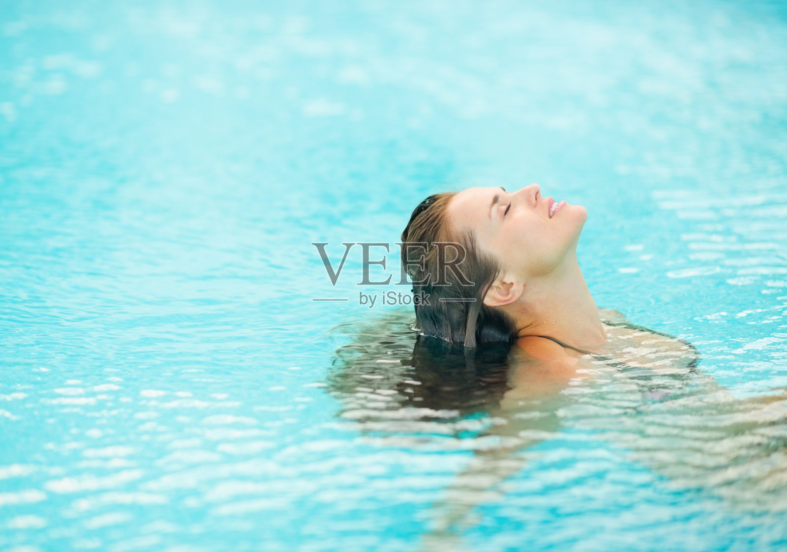 年轻女子坐在泳池里放松照片摄影图片