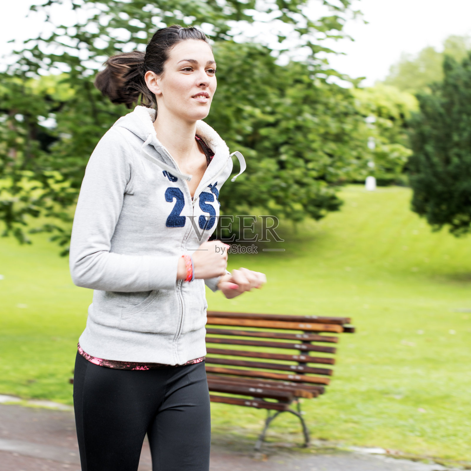 女孩在公园里跑步。照片摄影图片