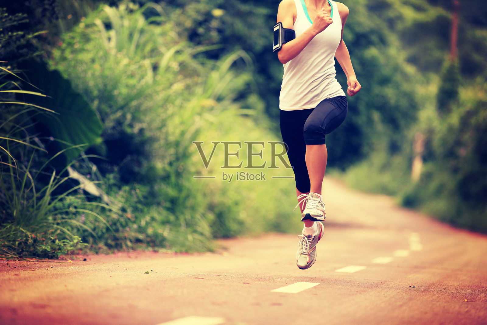 跑步运动员在森林小径上跑步。照片摄影图片