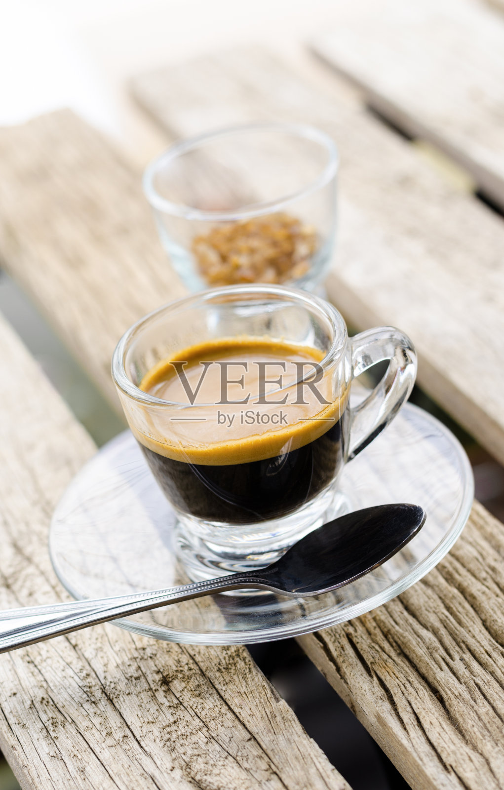 木桌上的玻璃杯里的浓缩咖啡照片摄影图片