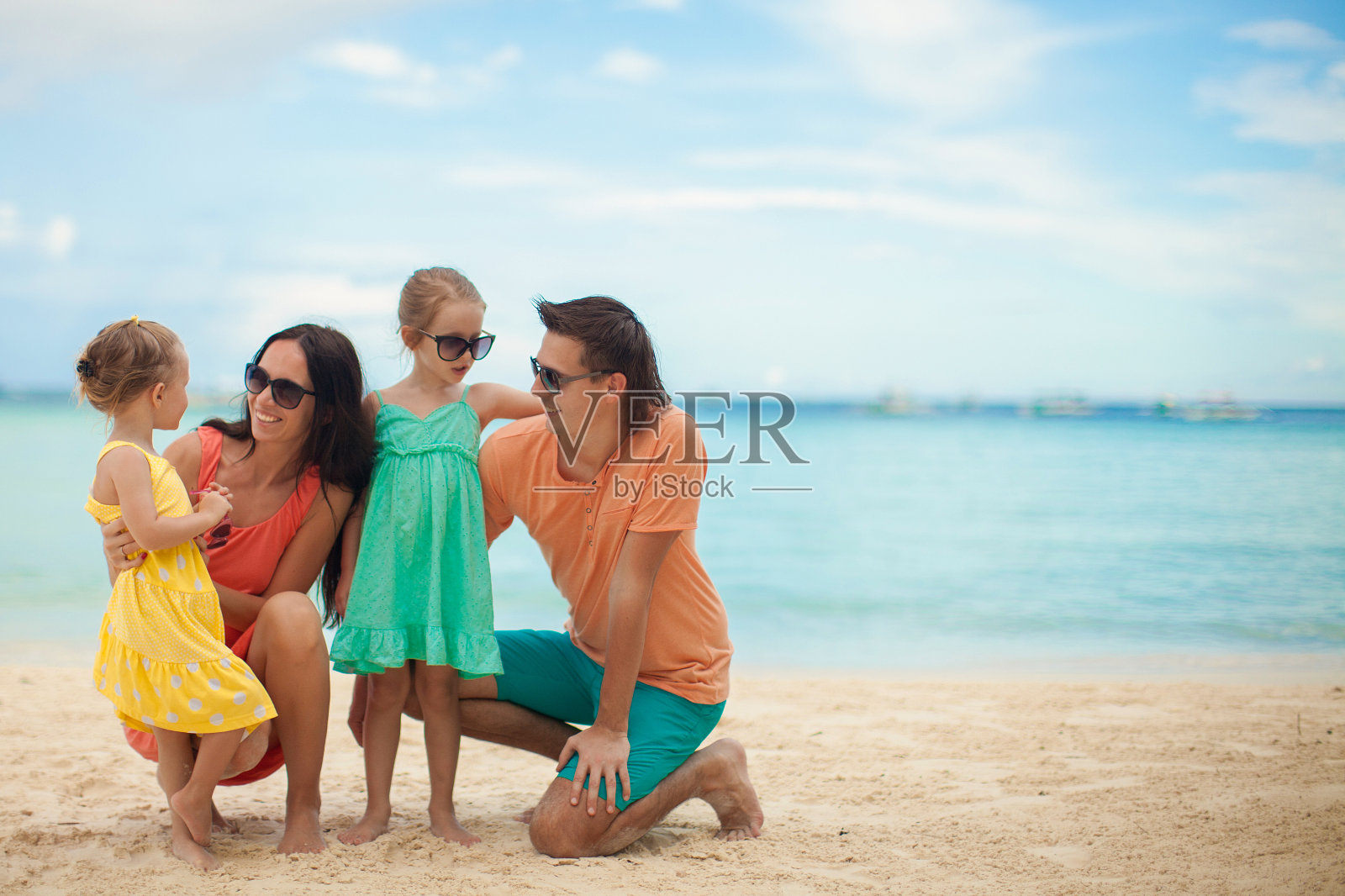 年轻美丽的四口之家享受着在海滩上放松的乐趣照片摄影图片