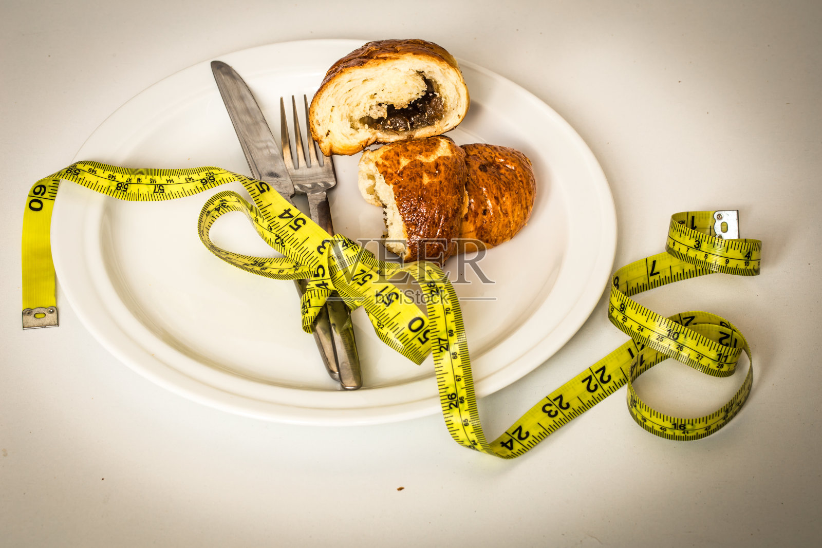 白色盘子配发髻，黄色卷尺照片摄影图片