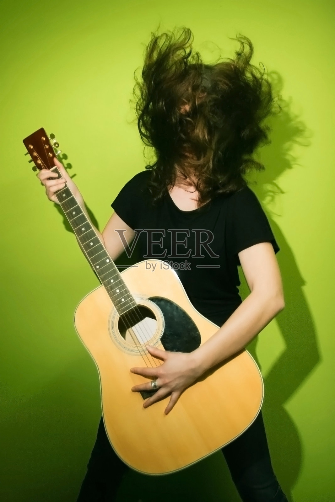拿着吉他摇晃头发的女人照片摄影图片