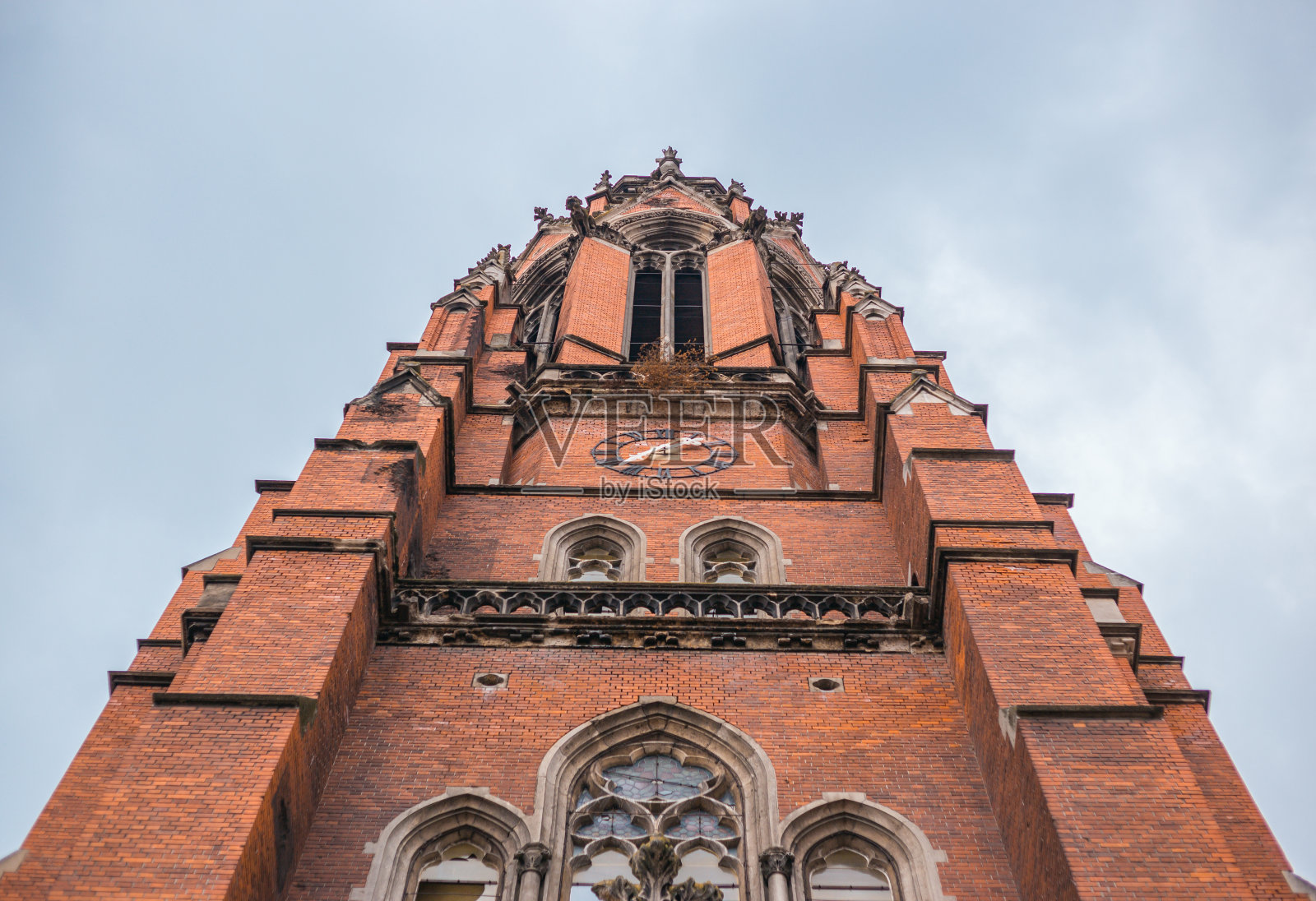 在多云多雾的日子里，巨大的砖砌基督教教堂照片摄影图片