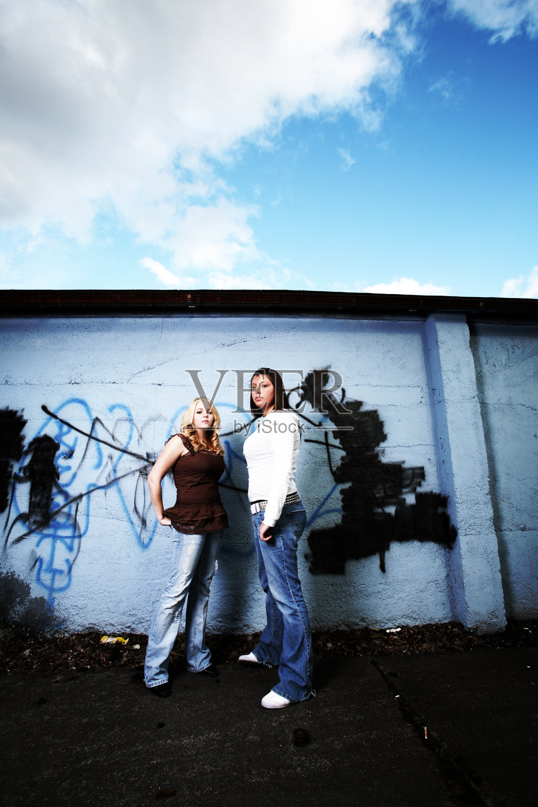 涂鸦墙前的年轻女孩。照片摄影图片