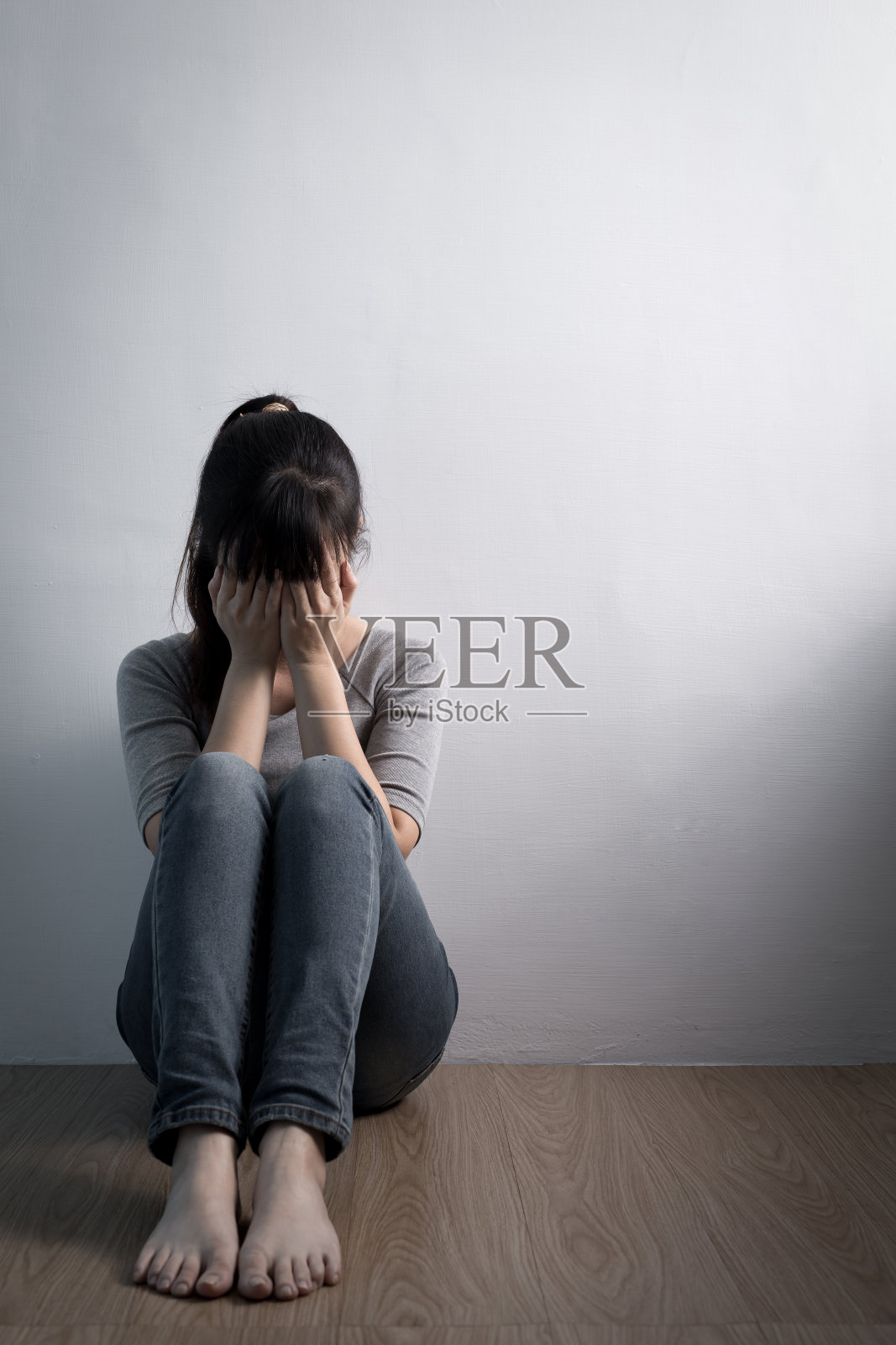 坐在地板上的抑郁妇女照片摄影图片