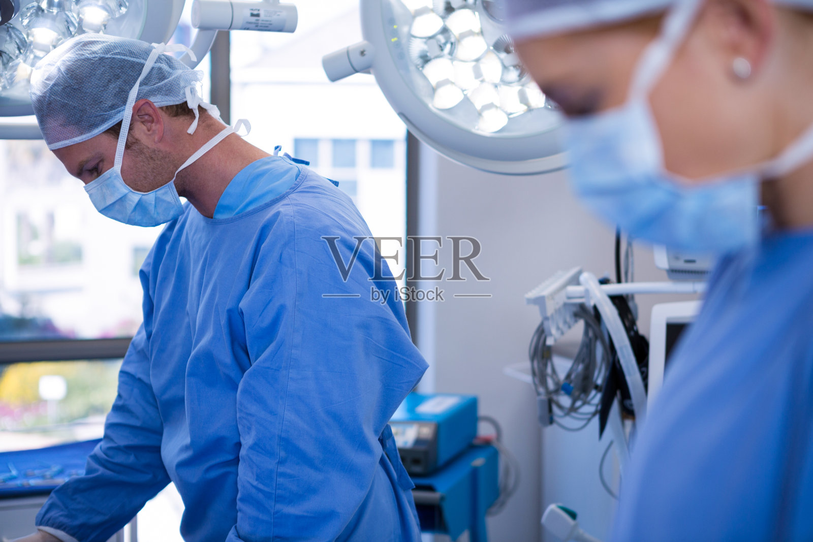 男女外科医生在手术室戴口罩照片摄影图片