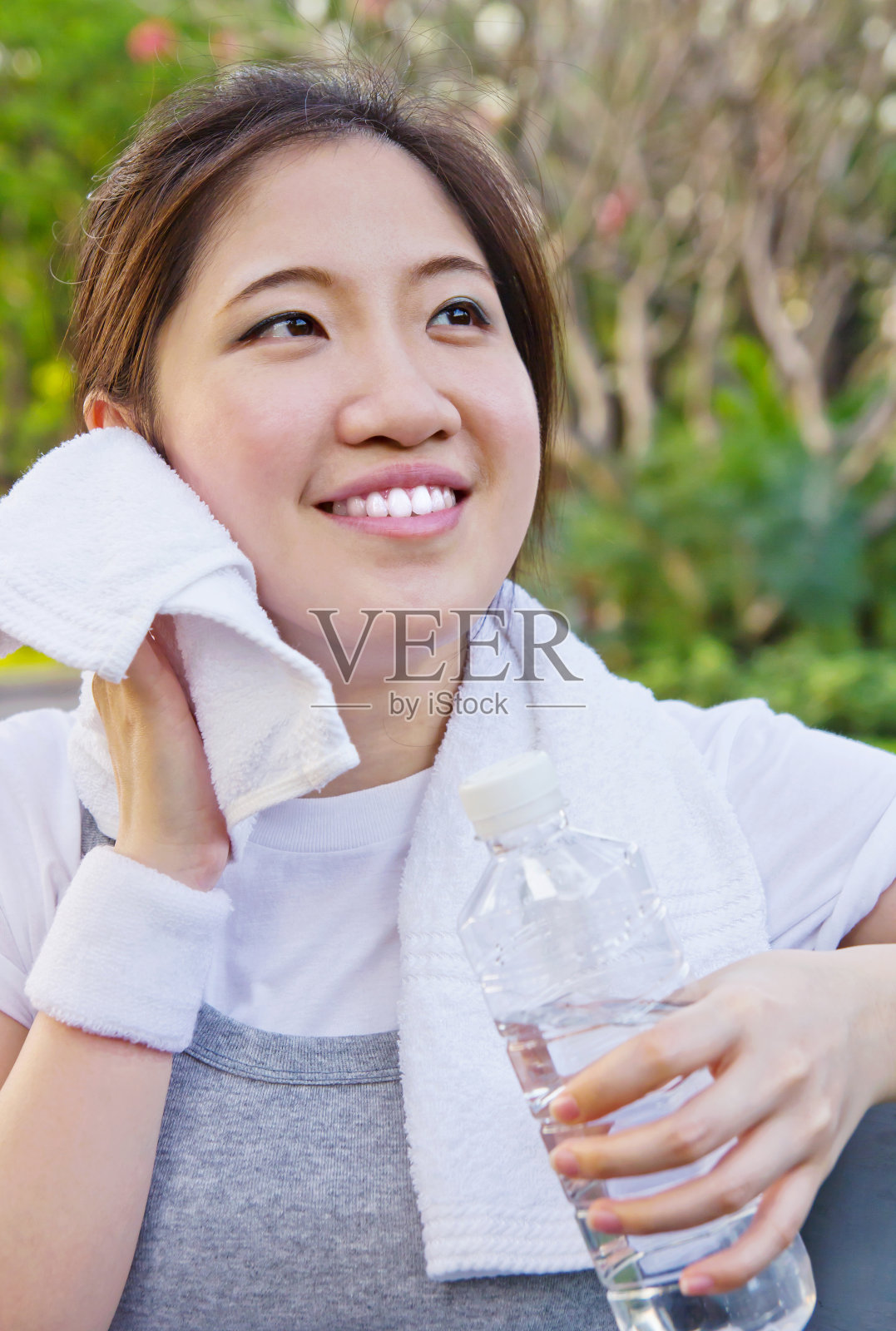 亚洲妇女在运动后用毛巾擦汗照片摄影图片