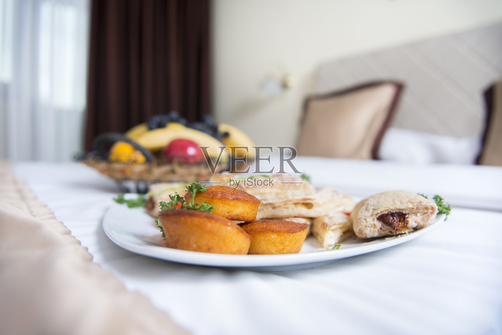 酒店房间里盘子里的甜百吉饼。照片摄影图片