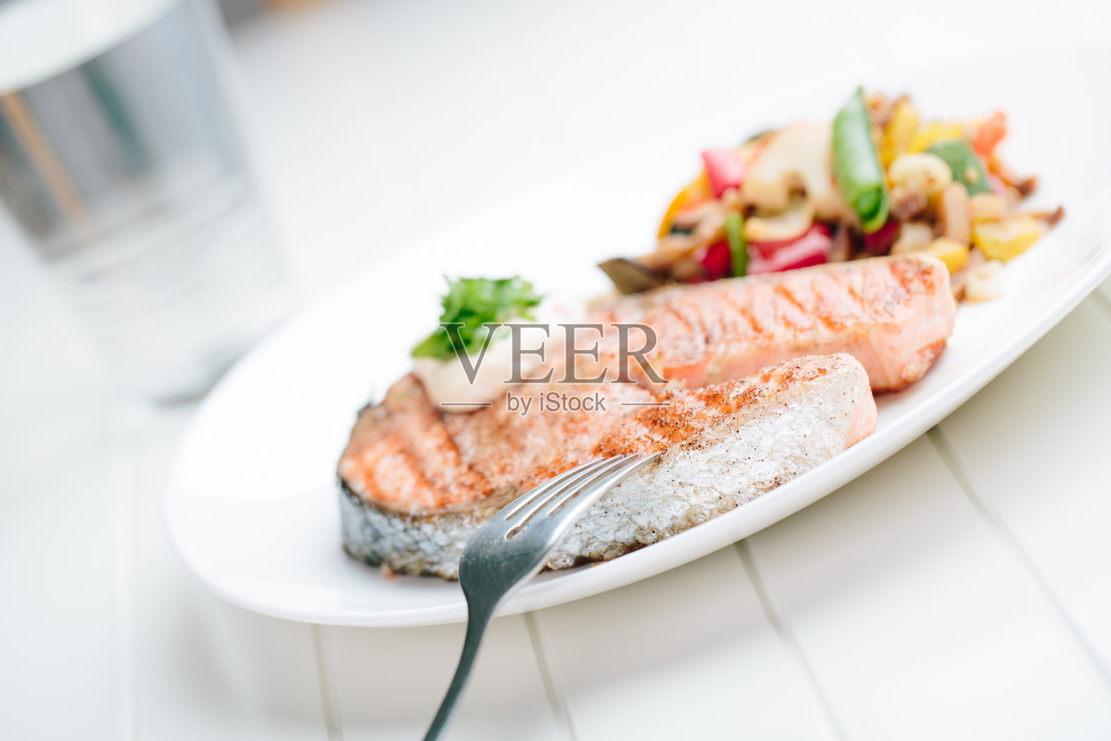 烤鲑鱼与新鲜蔬菜在白色的背景照片摄影图片