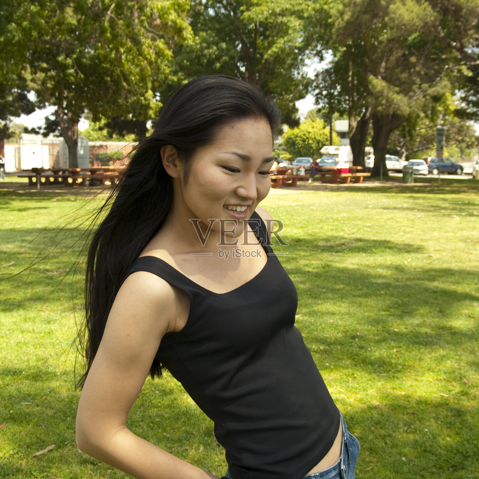 年轻的亚洲女人在公园里向下看照片摄影图片