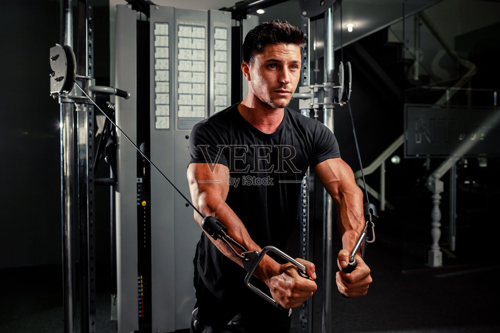 帅哥在健身房锻炼照片摄影图片