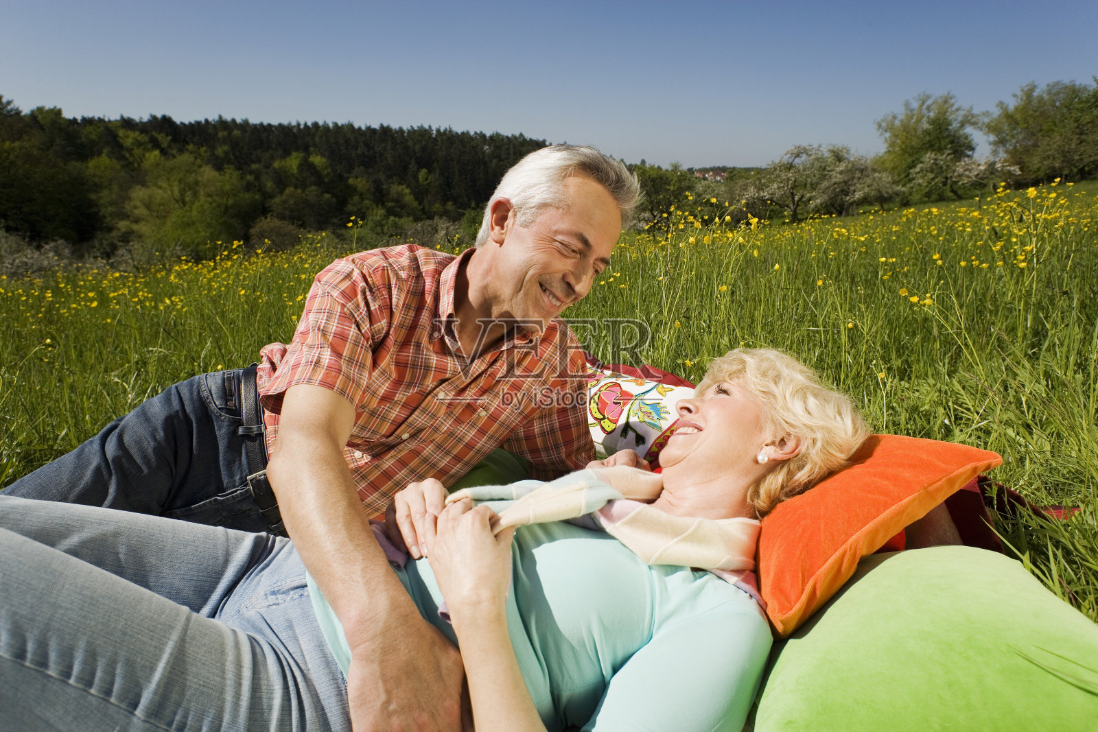 Tübingen，一对老年夫妇躺在草地上微笑拥抱照片摄影图片