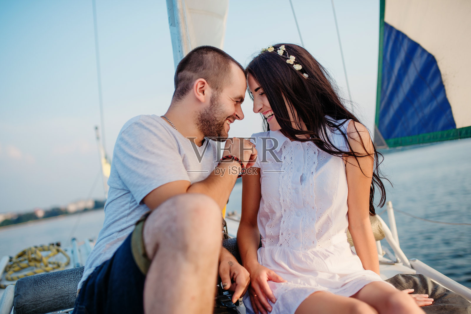 一对年轻漂亮的夫妇在游艇上度假。照片摄影图片