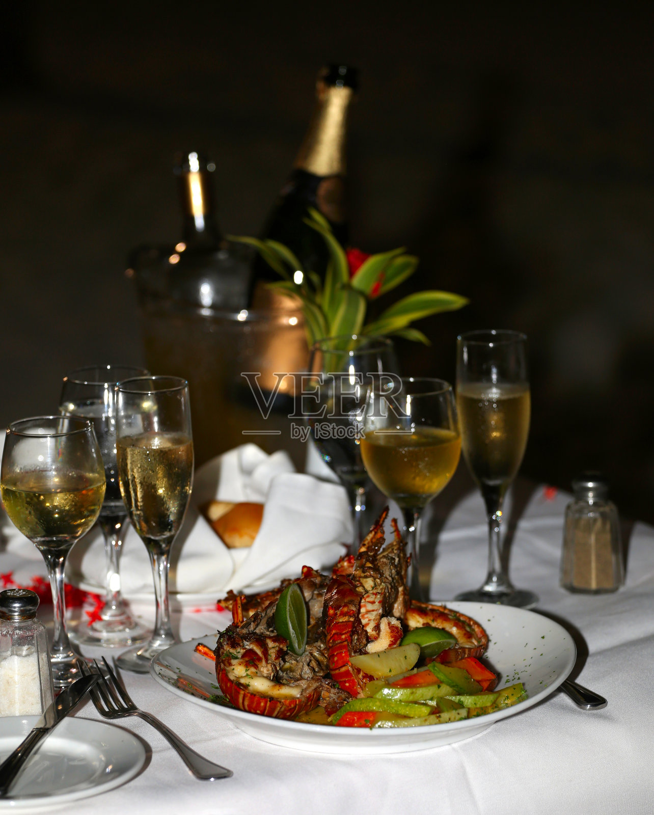 桌上放着龙虾和香槟杯照片摄影图片