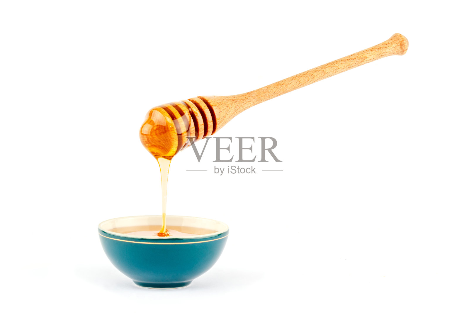 蜂蜜从碗里的勺子里流出来照片摄影图片