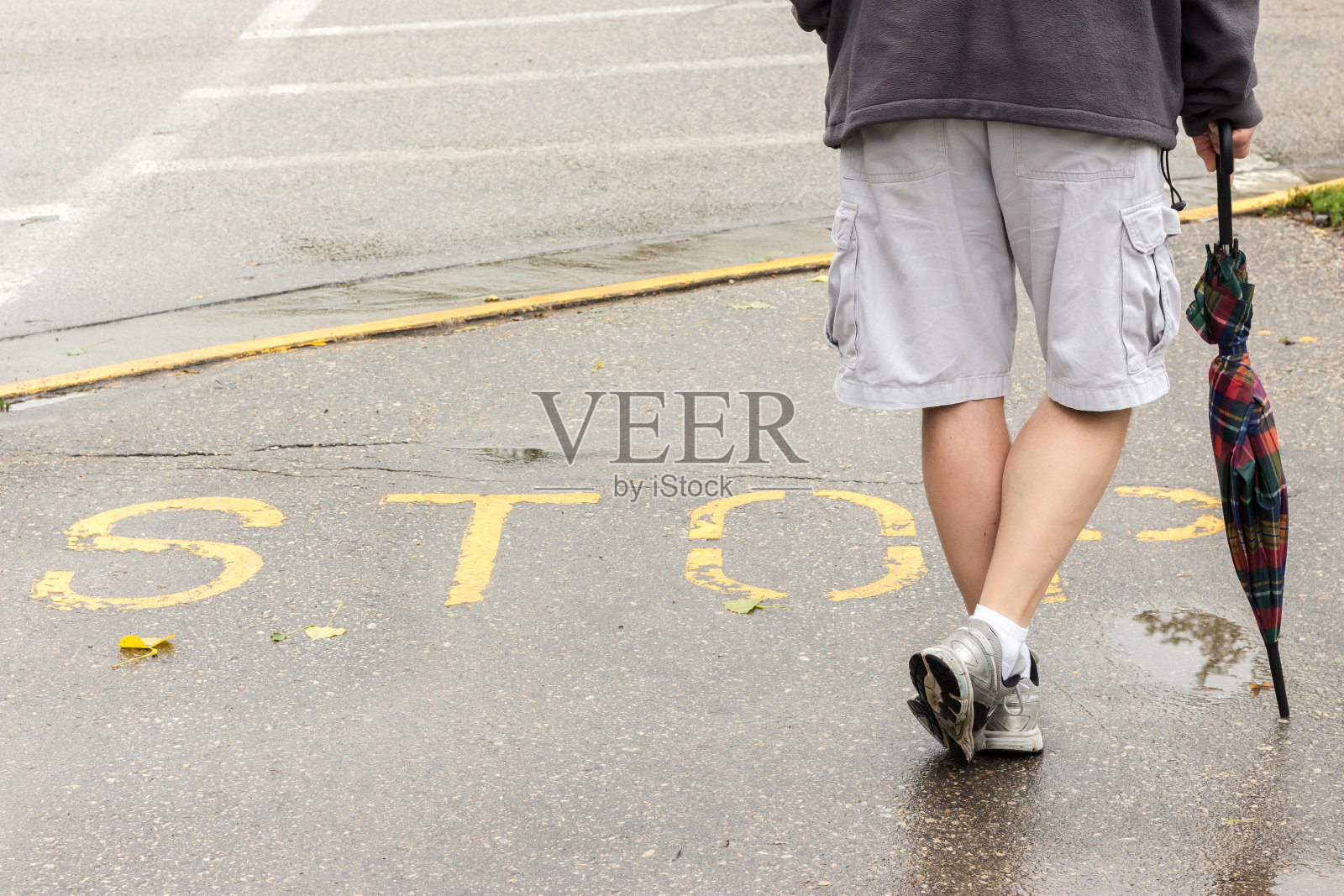 一名男子站在人行道上写着“停下”的标志旁照片摄影图片