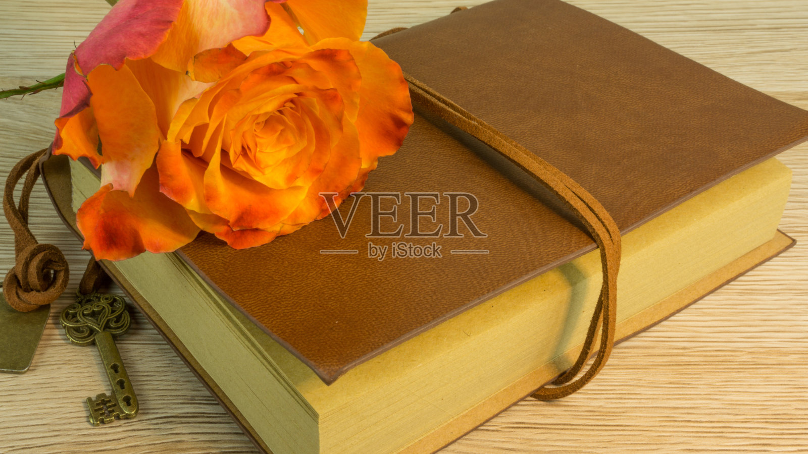 一本带钥匙的书和一朵玫瑰照片摄影图片