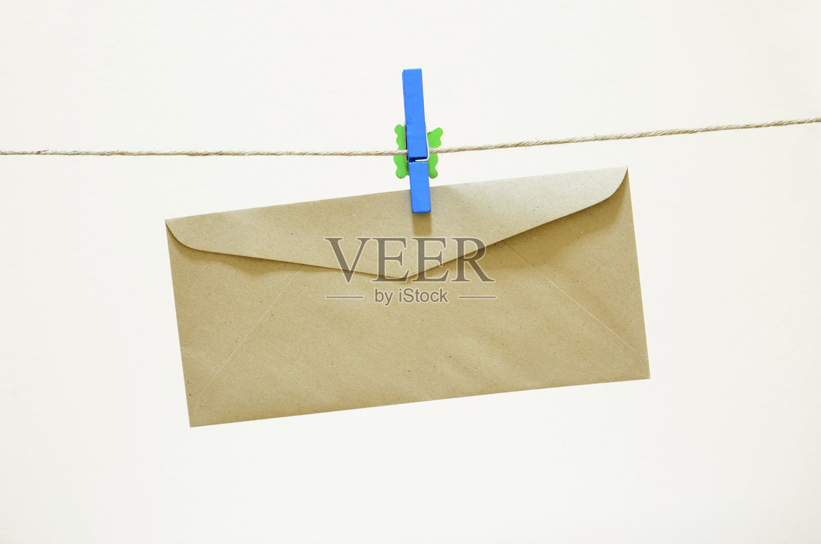 棕色的信封挂在一个蓝色的衣服别针上照片摄影图片