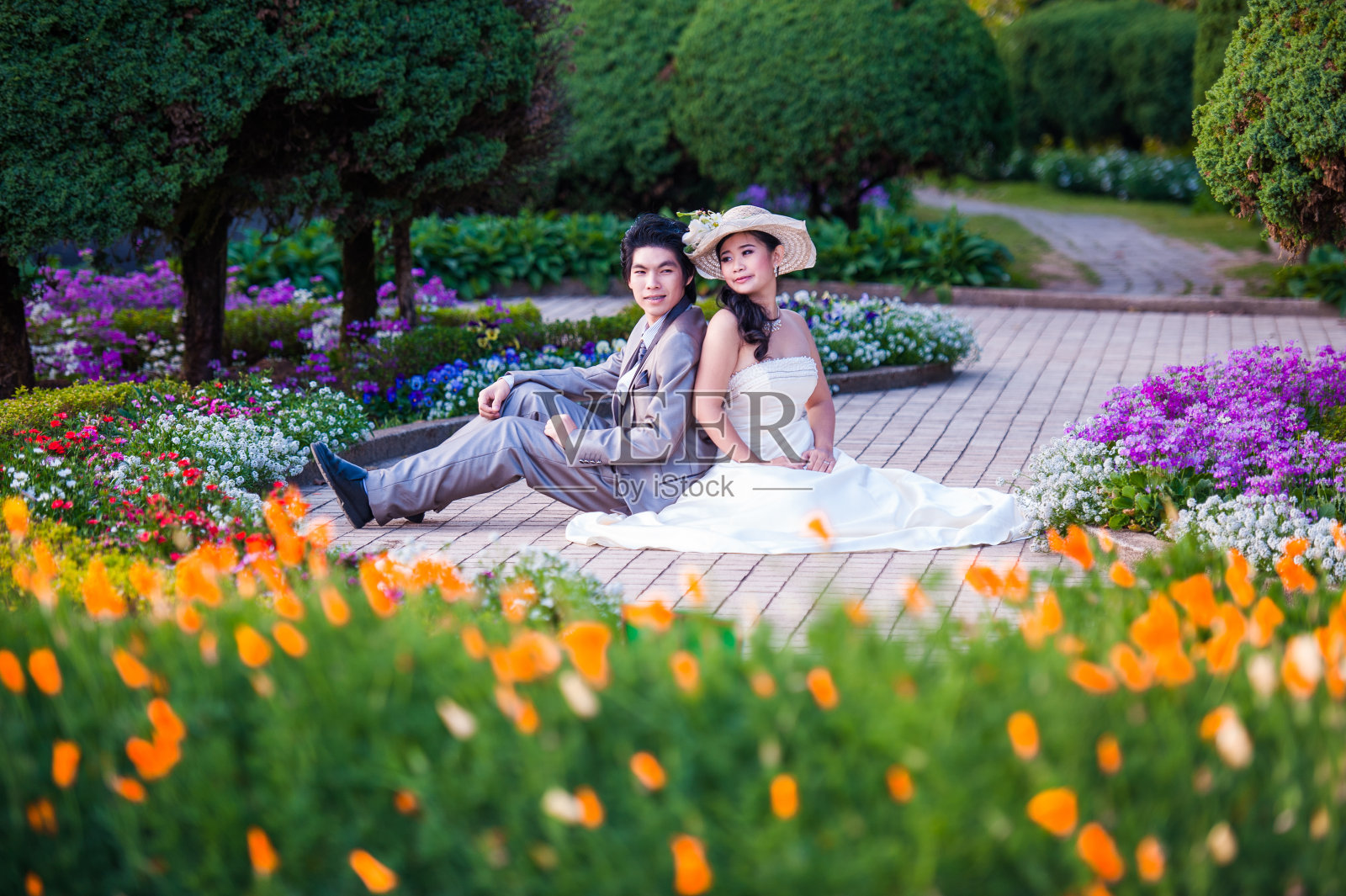 亚洲新娘和新郎一起坐在花园里照片摄影图片