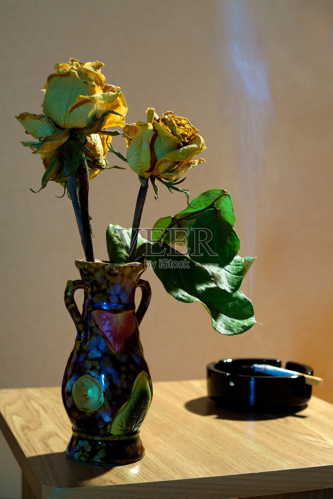 黄玫瑰，烟灰缸和香烟照片摄影图片