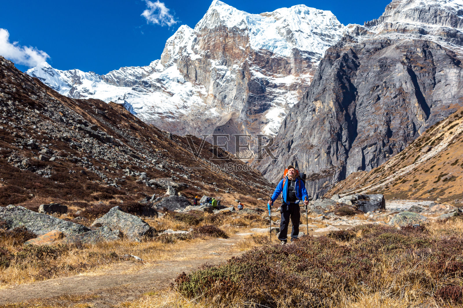 徒步登山的人走在以山峰为背景的小路上照片摄影图片
