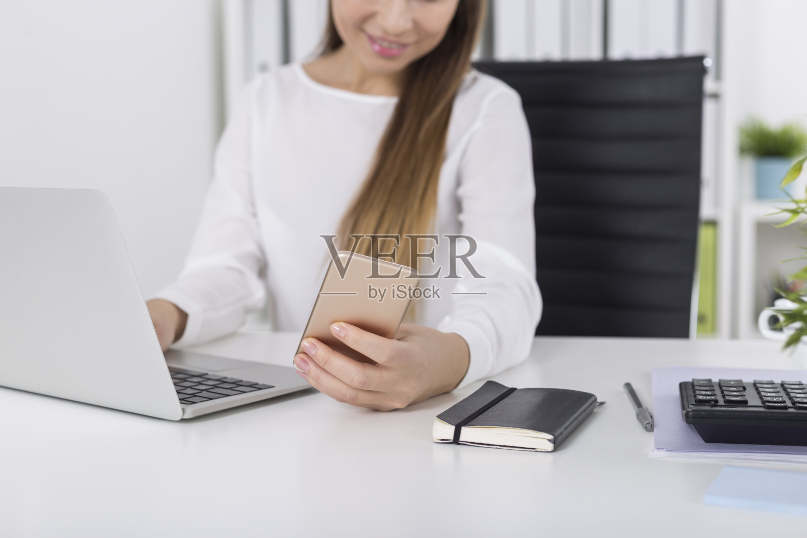 棕色长发的女孩在看手机照片摄影图片