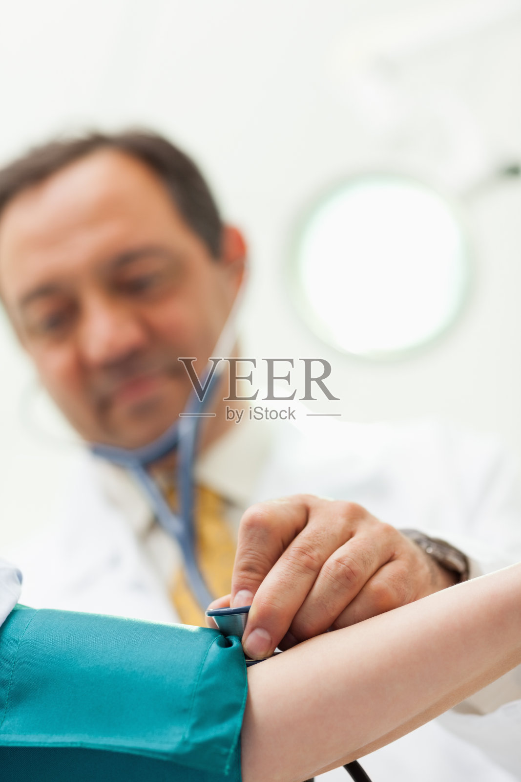 医生将听诊器放在病人的手臂上照片摄影图片