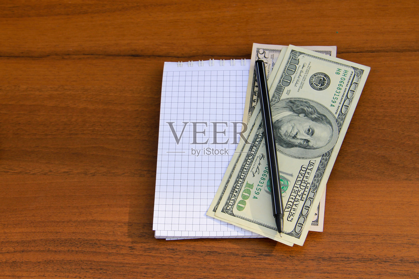 木桌上放着带笔和现金的记事本照片摄影图片