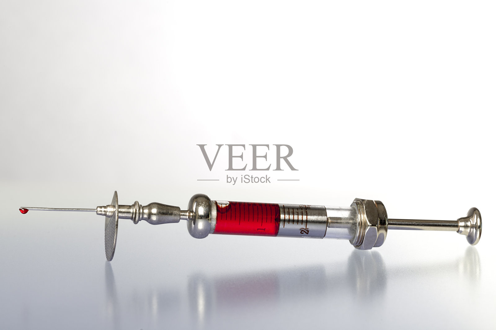 老式注射器与血液反射地下照片摄影图片