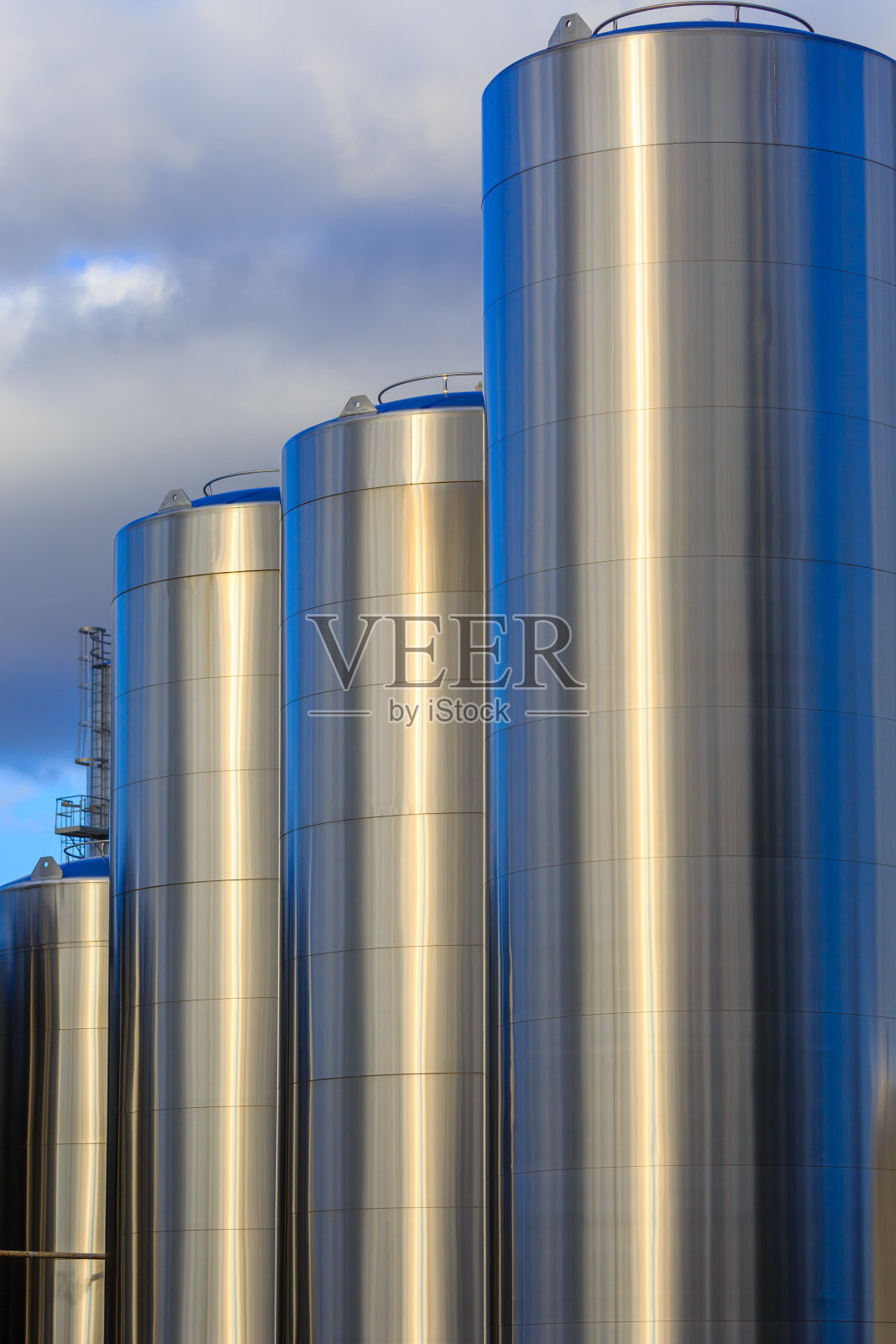 盛牛奶的不锈钢罐。照片摄影图片