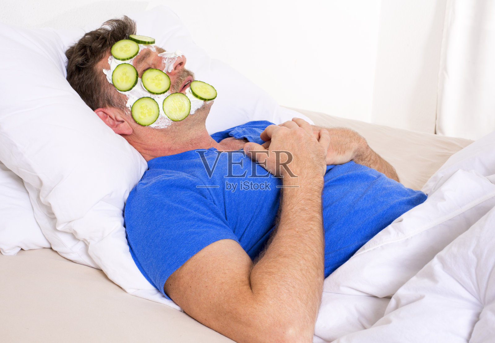 男人在床上做面部护理照片摄影图片