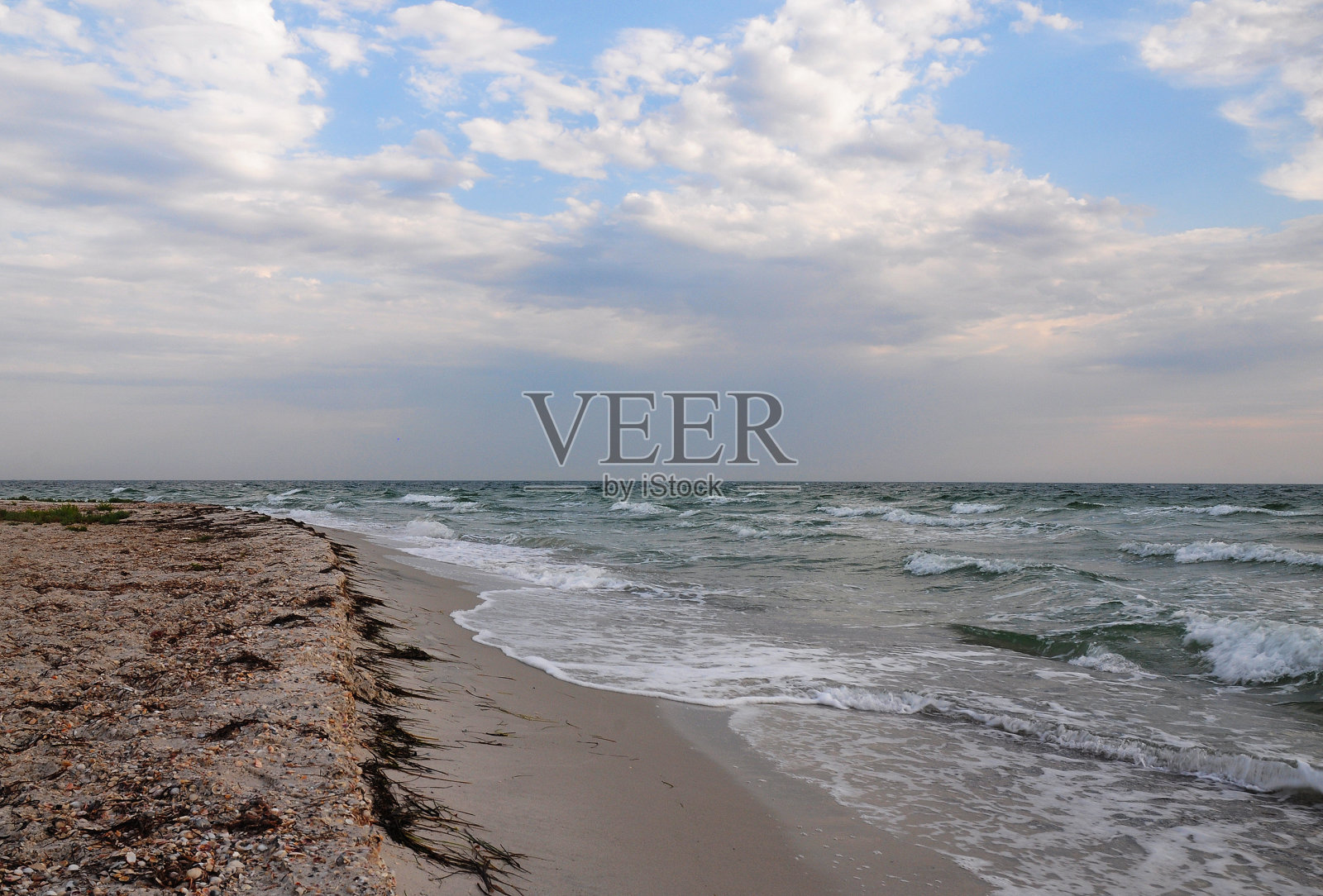 夕阳下沙滩上的海浪和沙滩。照片摄影图片