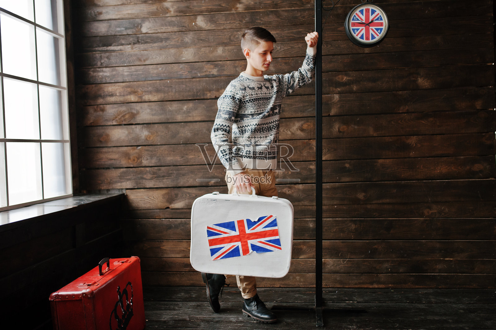 年轻时尚男士提着印有英国国旗的行李箱照片摄影图片