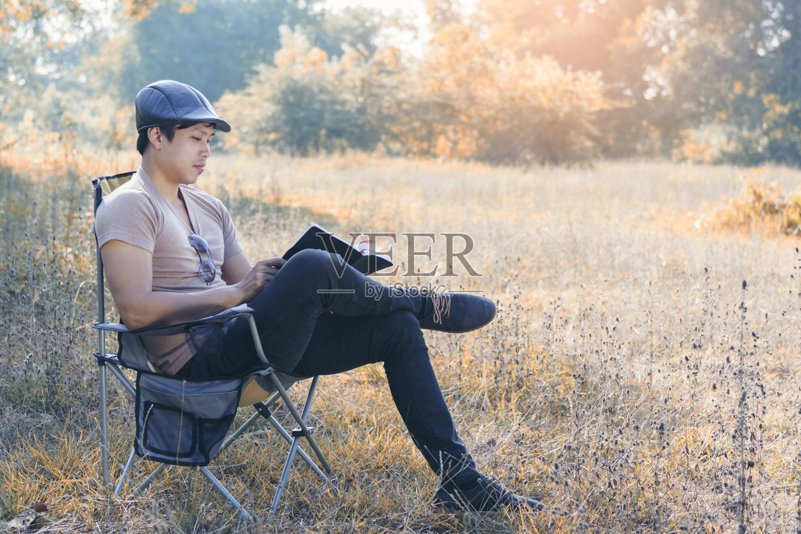 那个观光客坐在森林前的一把野地椅上休息照片摄影图片