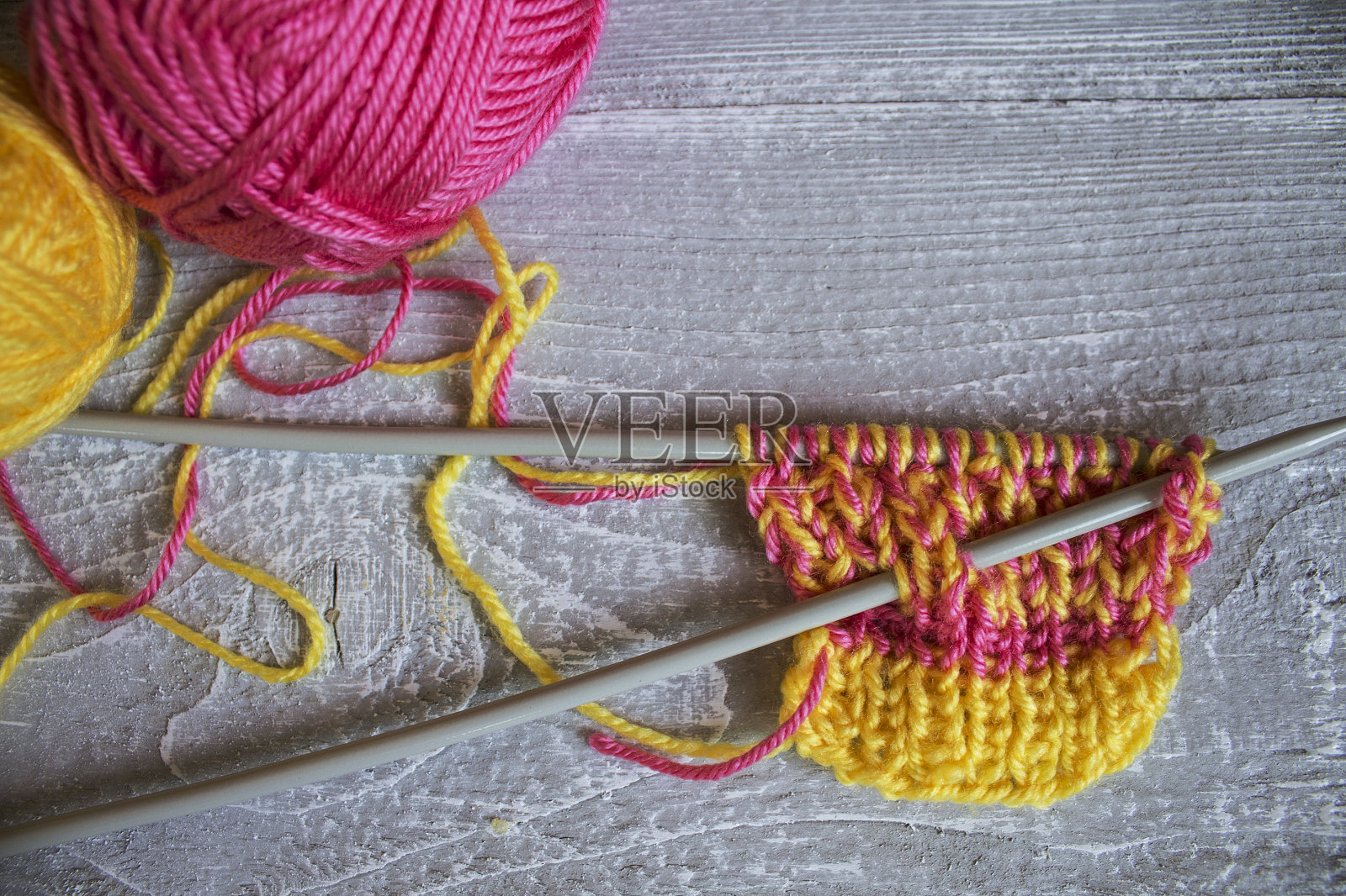 木桌上放着编织针和一根彩色线照片摄影图片