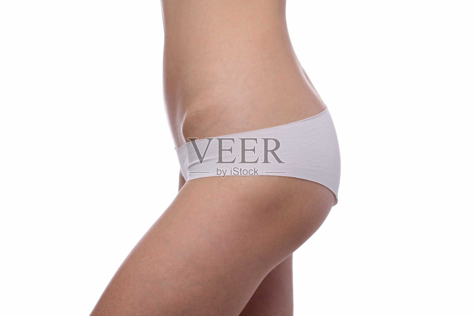 美丽苗条的女人穿着白色内衣孤立。健康的女性身体，躯干，纤细的腰部，腹部，腹部近。运动，健身，节食结果。照片摄影图片