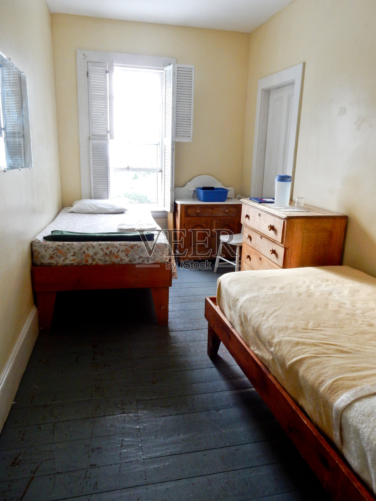 窄小的房间，有旧的两张单人床照片摄影图片