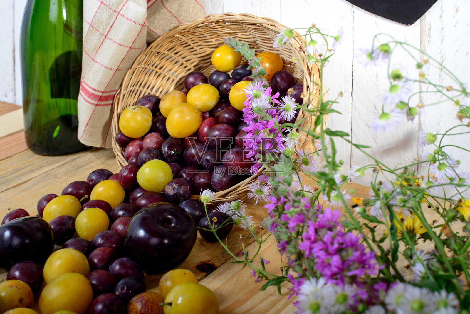 木桌上放着红色和黄色的李子照片摄影图片