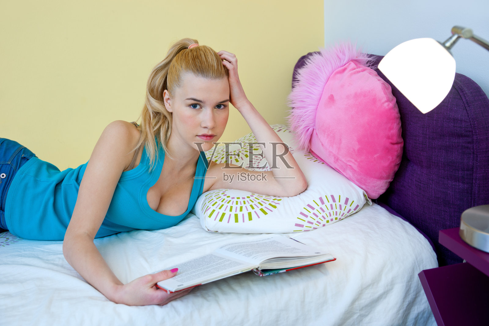 十几岁的女孩在床上看书照片摄影图片