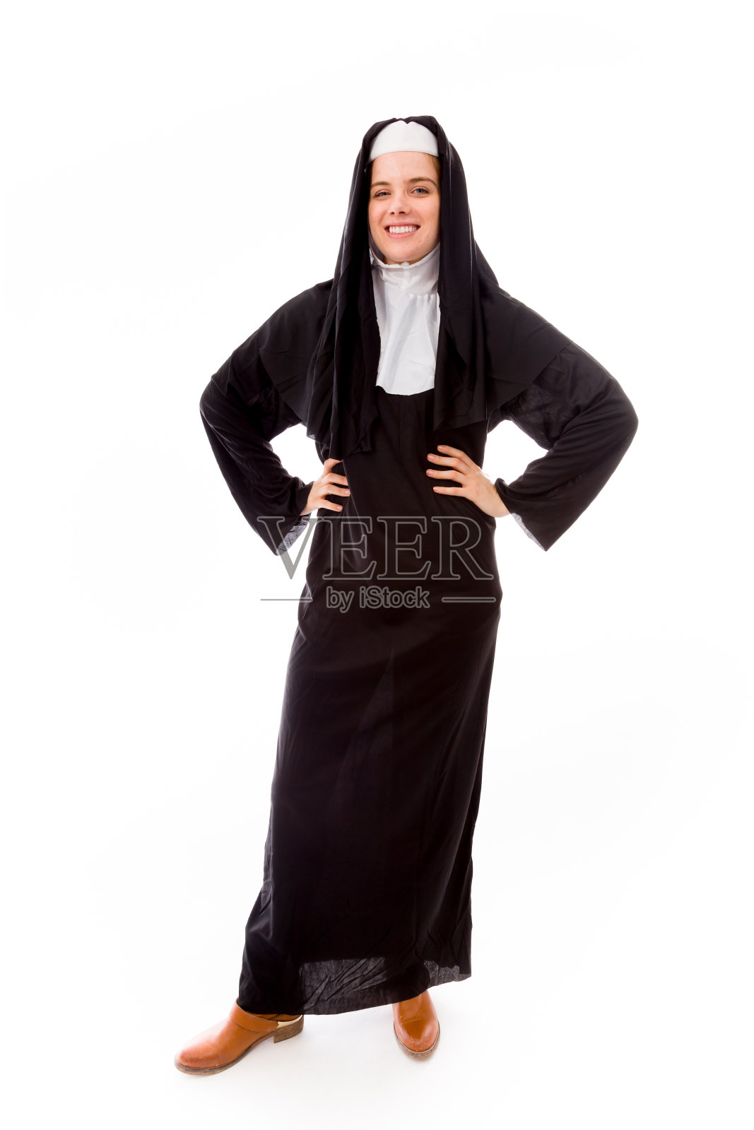 年轻的修女微笑着，双手叉腰照片摄影图片