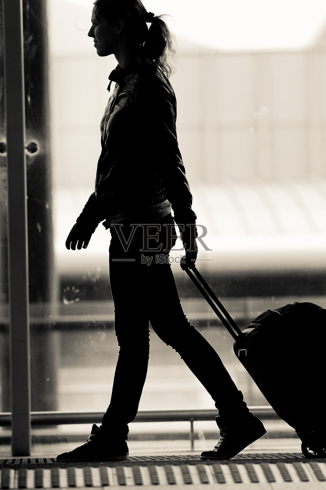 一位女士在机场候机厅帮你拿行李照片摄影图片