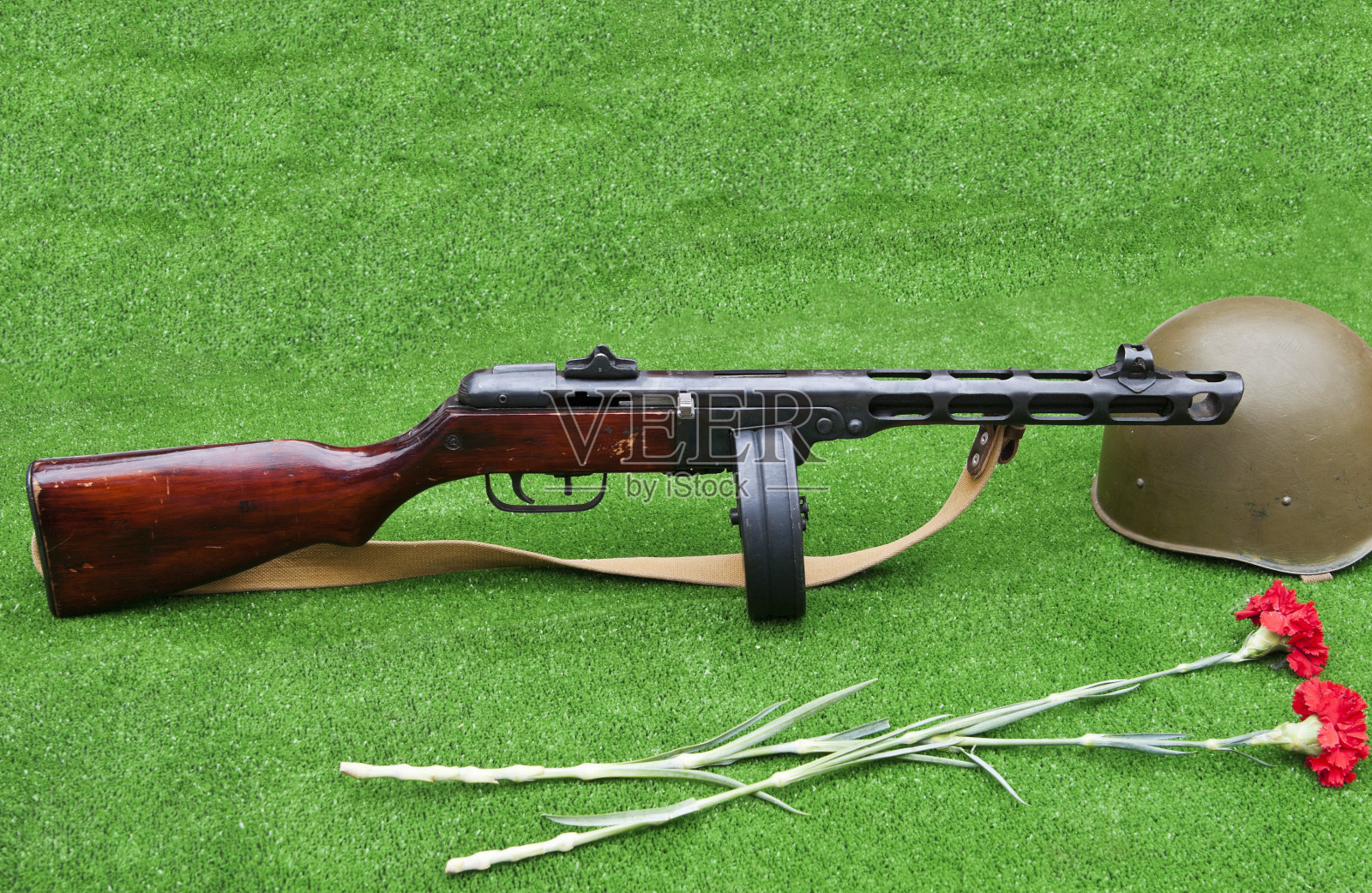 冲锋枪Shpagin (PCA)，士兵头盔，两朵康乃馨照片摄影图片