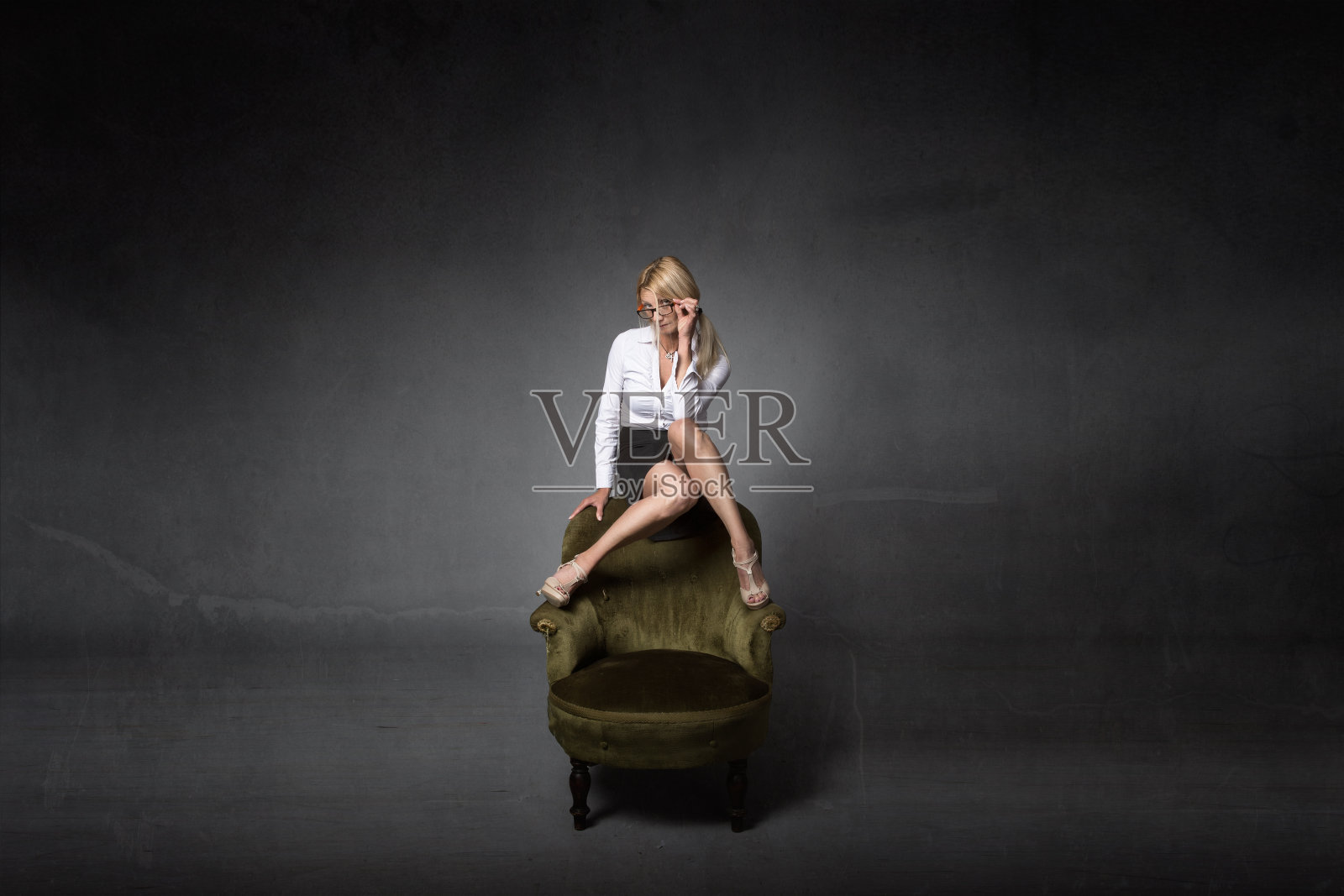 漂亮的金发女人，脚坐在沙发上照片摄影图片