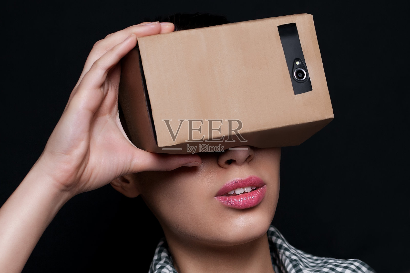 一个年轻女人透过纸板看的彩色照片照片摄影图片