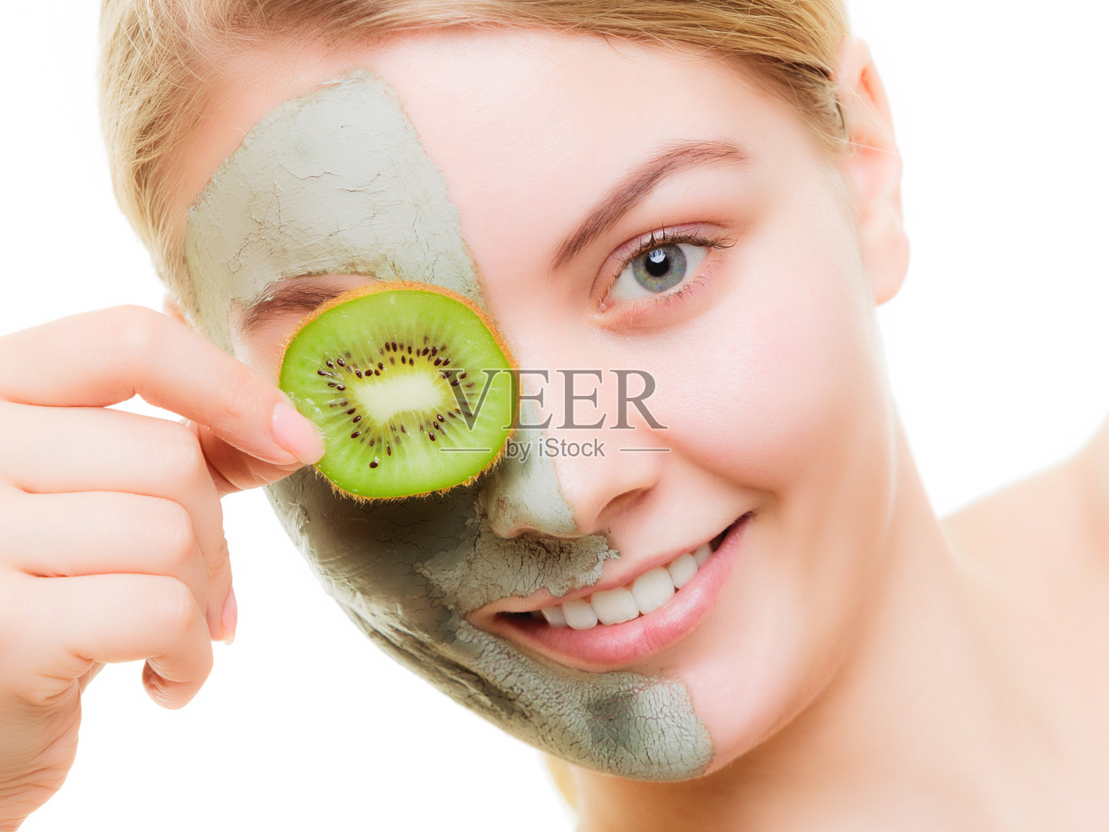 女人在粘土面具的脸覆盖眼睛与猕猴桃照片摄影图片