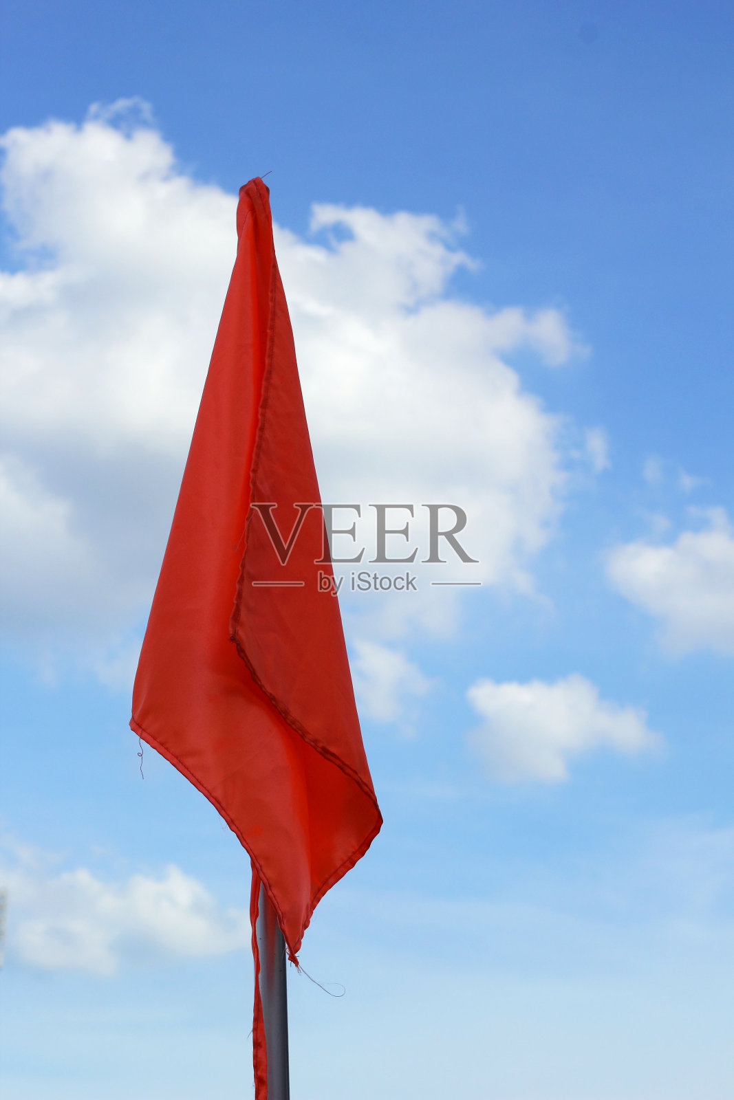 蓝色天空上的橙色旗帜。照片摄影图片