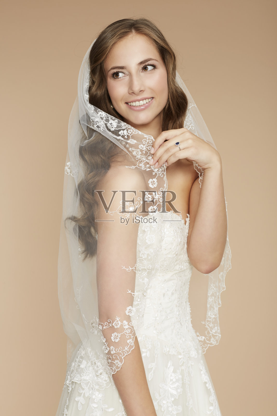 美丽的年轻新娘在婚纱拿着面纱照片摄影图片